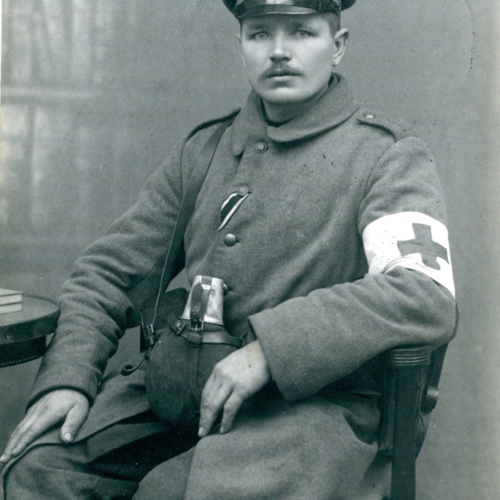 Sanitäter im Mantel mit Labeflasche aus dem Reserve-Infanterie-Regiment Nr. 1. Originale Fotopostkarte, gelaufen am 28.01.1916.