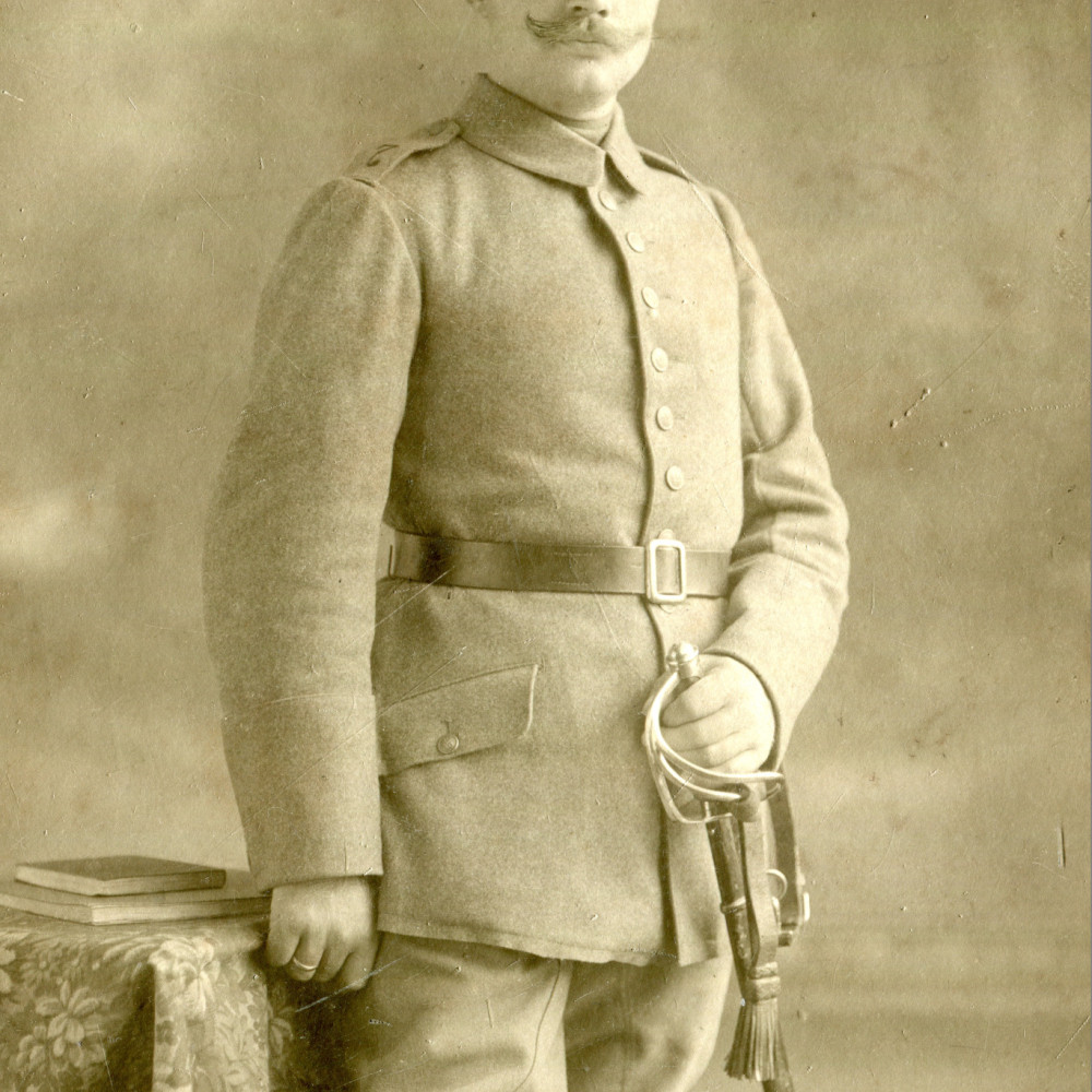 Trainsoldat in feldgrauer Uniform (vereinfachter Waffenrock) wohl mit einem Kürassierpallasch am geschwärztem Überschnallkoppel.