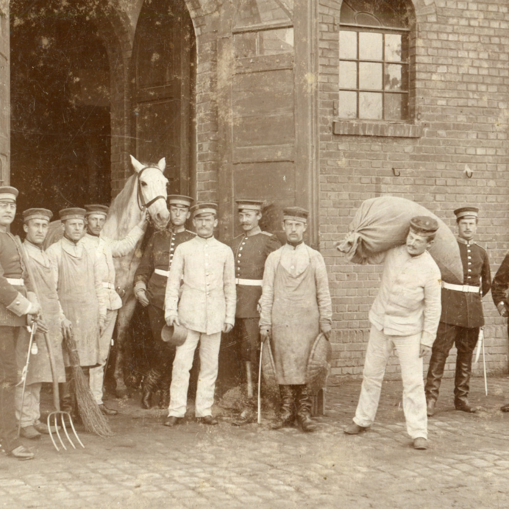 Angehörige des Westfälischen Train-Bataillons Nr. 7 vor dem Stallgebäude.